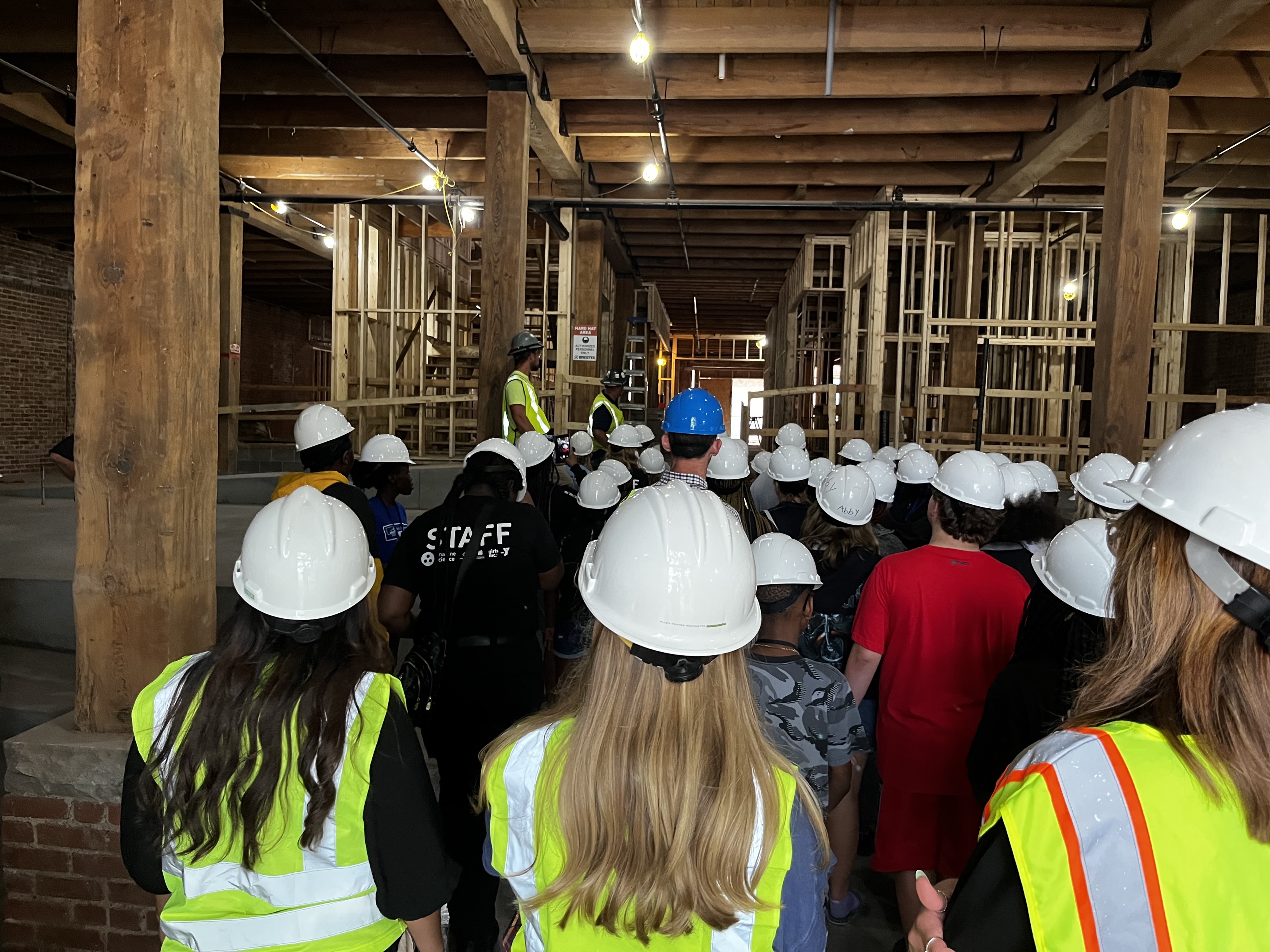 students with hard hats on in the college of architecture immersion mimp at a site with an employer