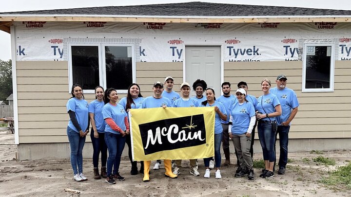 Employees holding a 'McCain' flag at a volunteer event