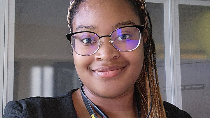 Black female student with glasses smiling