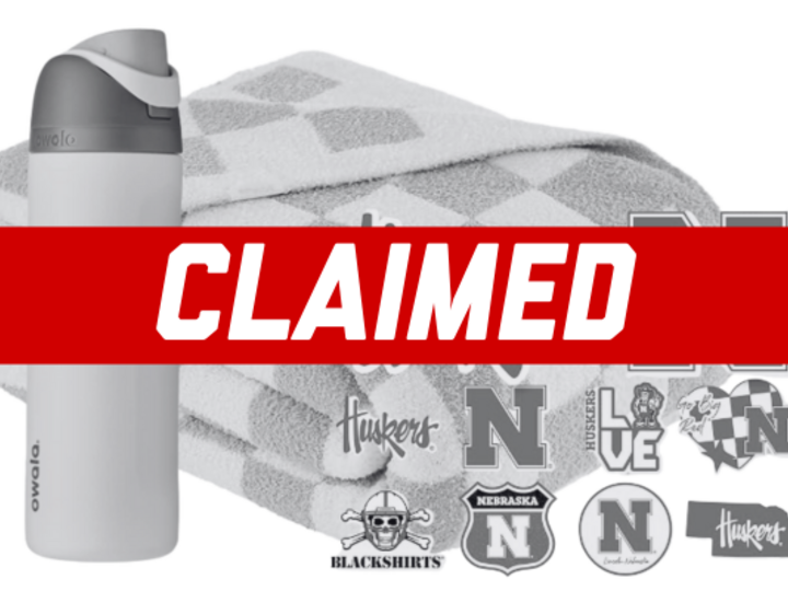 Stickers, a water bottle, and a blanket with a 'claimed' banner over them