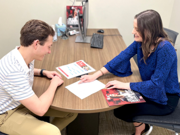 Female Career Peer Guide helps male student with their resume