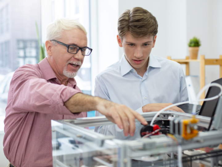 male professional showing student a machine